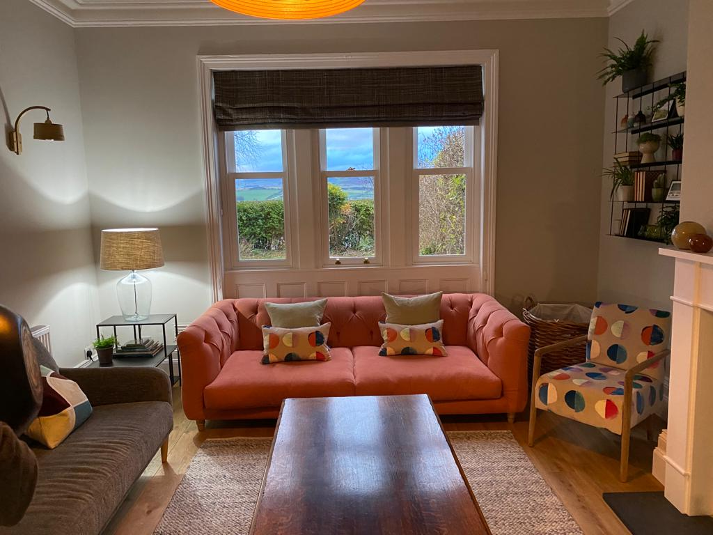 A living room with a couch and a coffee tableDescription automatically generated